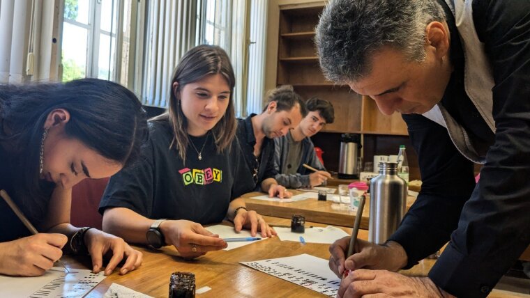 Studierende bei einem Kalligrafiekurs