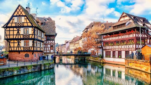 Strasbourg, Fachwerkhäuser entlang des Flusses Ill, blauer Himmel mit Wolken im Hintergrund