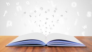 Buchstaben fliegen über Buch