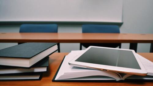 Ein Tablet und Bücher liegen auf einem Tisch
