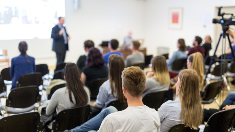 Studierende, die interessiert einem Vortragenden zuhören