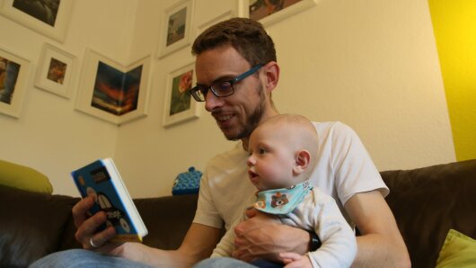 Vater und Baby schauen ein Buch an