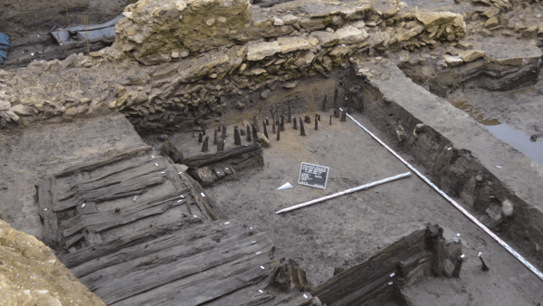Regensburg Donaumarkt / „Museum der Bayerischen Geschichte“. Uferbebauung um 1000: Blick von Nordwest auf den freigelegten Bohlenweg und Gebäude 1, im Hintergrund die Stadtmauer des 11. Jahrhunderts.