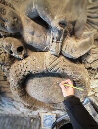 Oberflächenreinigung einer Grabplatte am Ausstellungsort